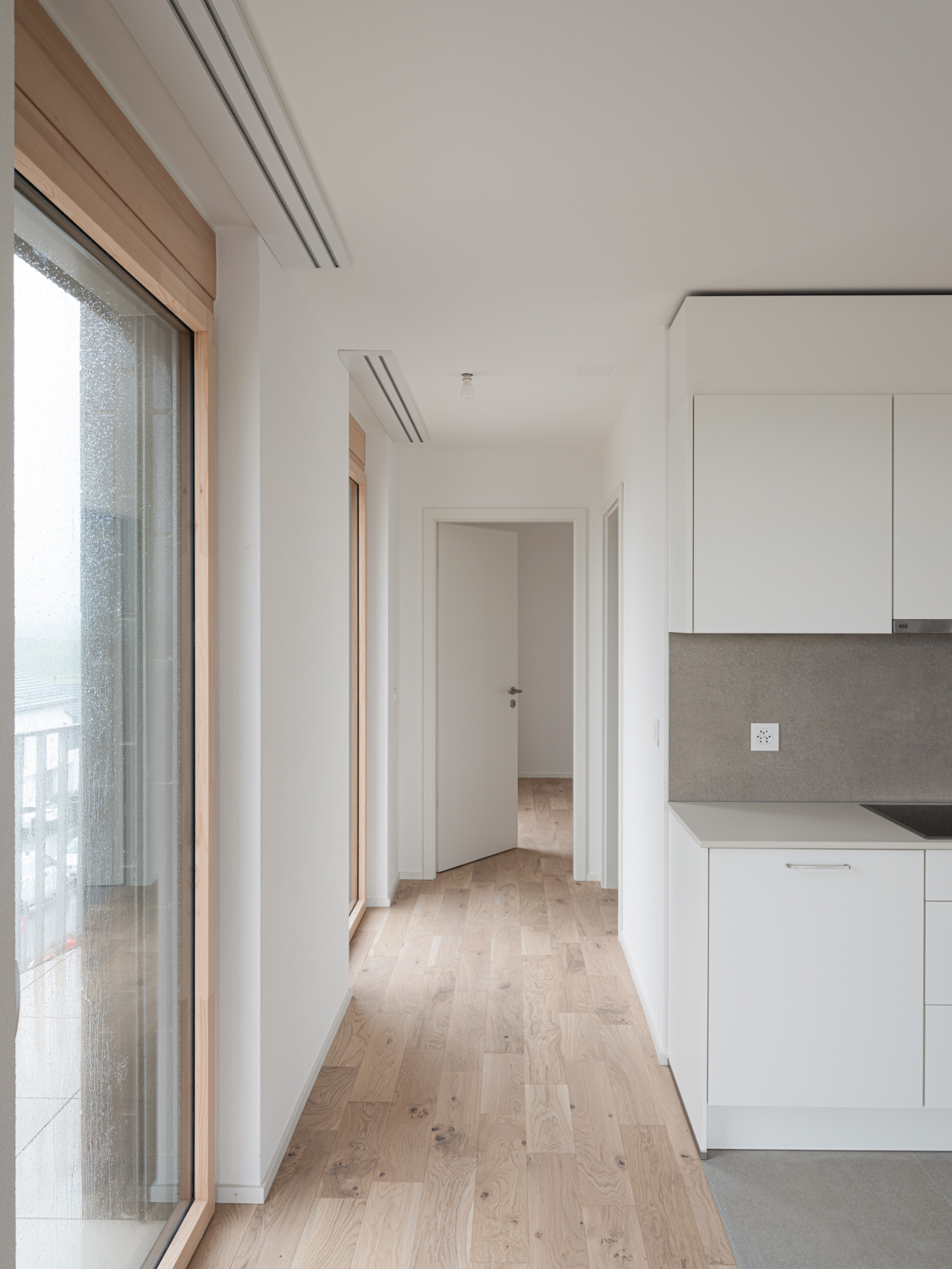 Intérieur d'un logement neuf, Panorama Bussigny, lumière naturelle et volumes bruts